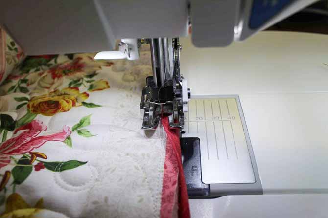 Stitching the final binding seam on the front of the quilt by machine