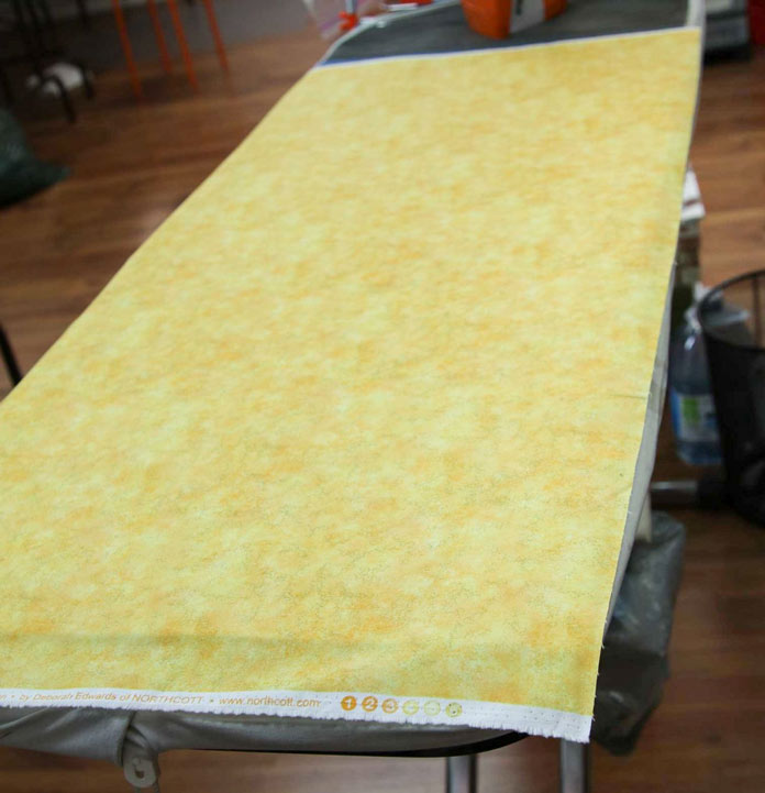 Press the backing (from the middle) of the three layers of the table runner to be quilted.