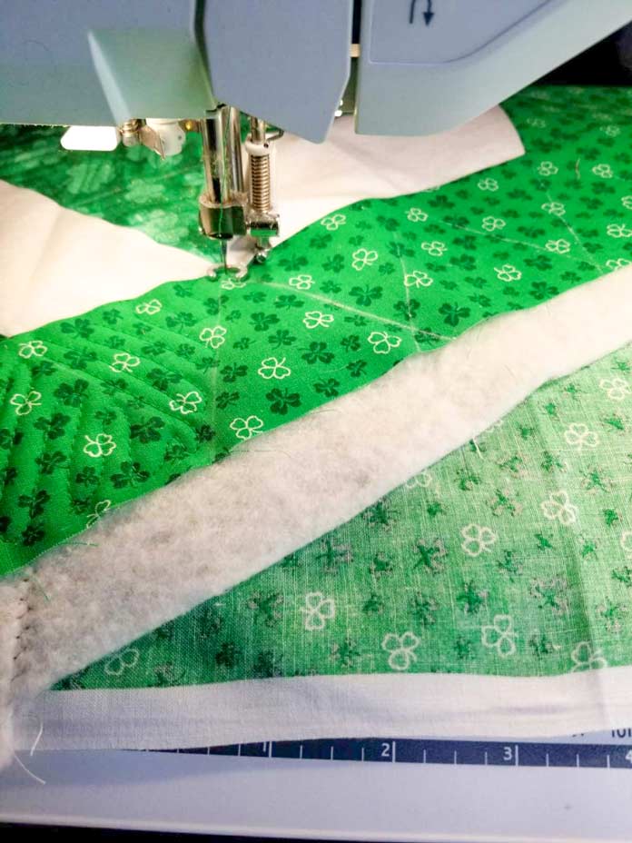 The batting and backing are extended beyond the edge of the table topper to provide optimal control when quilting