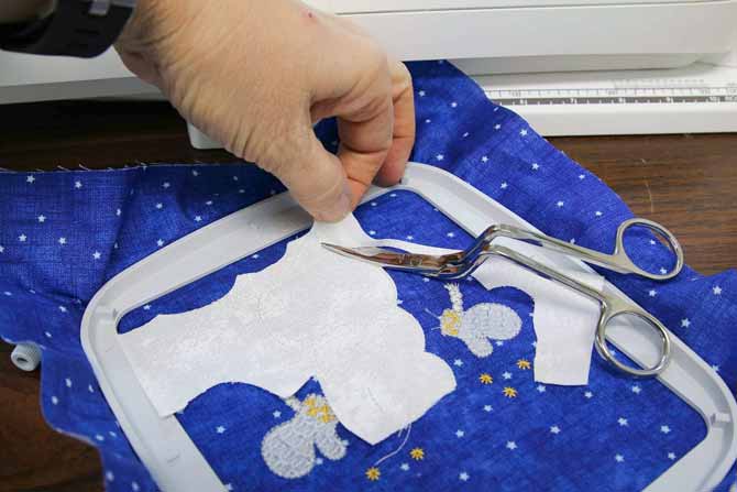 Using bent handled scissors to trim as close as possible to the tacking stitches
