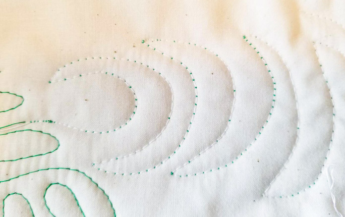 Green thread popping up through the quilting stitches