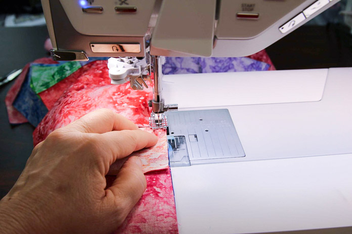 Inserting the next pair of squares to be sewed in the chain piecing process