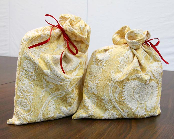 Two elegant gift bags tied with bright red ribbon