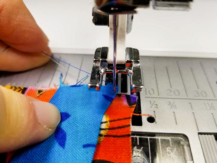 Hold the threads as you start to prevent thread nests on the underside of the work