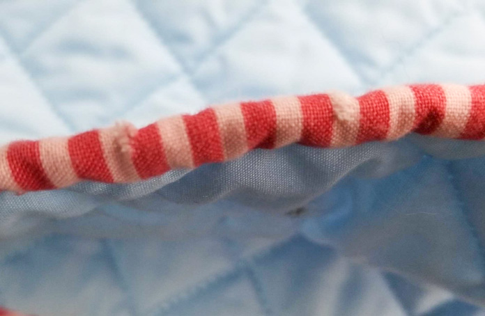 Frayed edges around the damaged binding cut on the crosswise grain