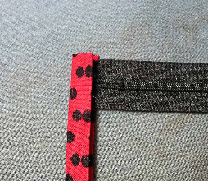 The ends of the zipper are too long. Cut them off to fit the zipper tab.