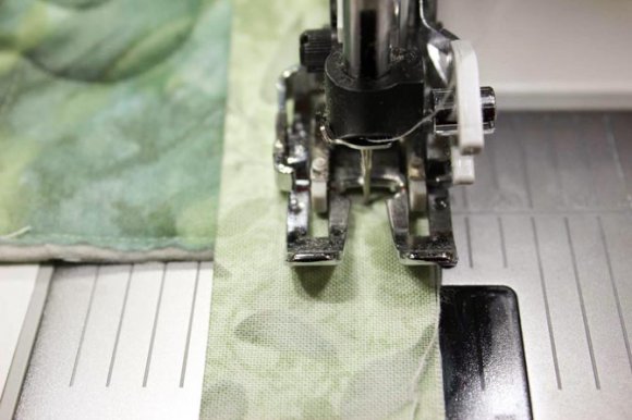 Right most opening on the Interchangeable Dual Feed foot is used as a guide for the binding seam allowance.