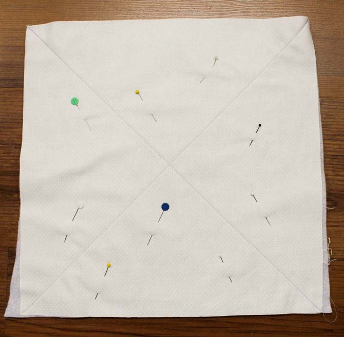 Fabric is marked with two diagonal lines in preparation for the quilting