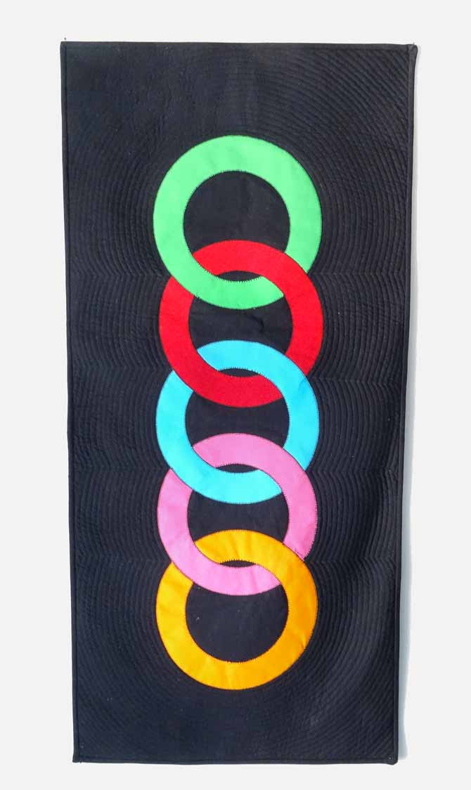In this shot, you can see the quilting better in the Linked Circle quilted wall hanging.