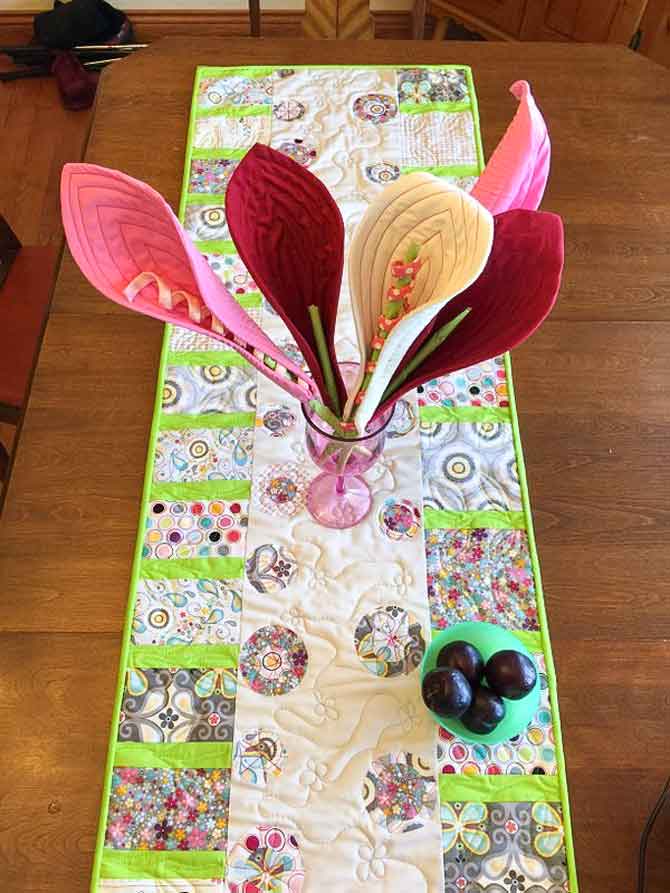 Modern table runner with fused flower circles and pieced stems.