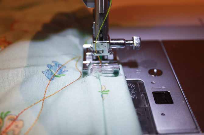 Using a decorative stitch and the A Presser Foot to apply binding to the front of a quilt.