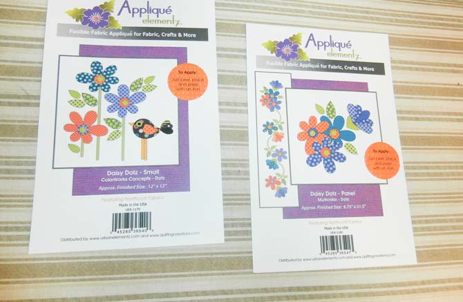 Two packages of precut and prefused appliques; one featuring flowers and a bird, the other featuring flowers only from Northcott's Urban Elementz Applique collection.