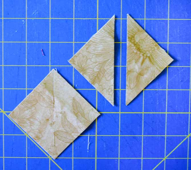Here on the cutting mat are the smaller beige triangles which have been cut diagonally once to make the smaller setting triangles.
