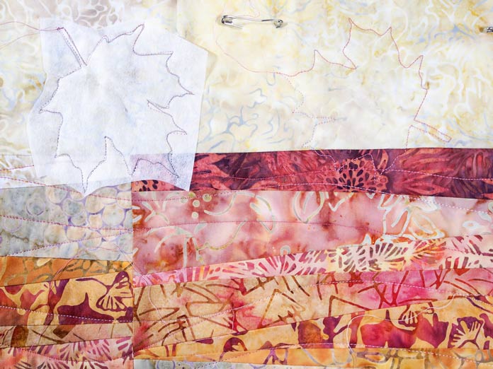 Maple leaf motifs stitched in border using tear away as a template