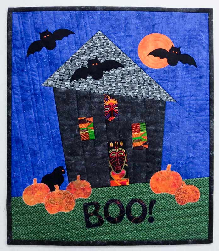 Finished Halloween quilt of a haunted house with bats and pumpkins; Brother NQ700, Brother BQ3050, and HeatnBond Feather Lite