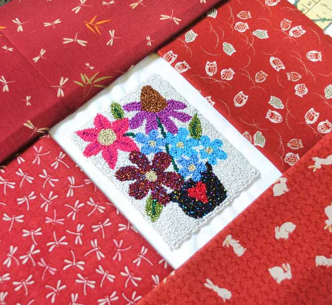 The Razzle and Dazzle punchneedle embroidery can be sewn into a quilt or pillow by sewing borders to the weaver's cloth