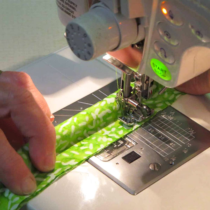 Use a zipper foot to stitch close to the cording.