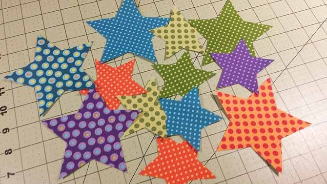 The 12 star applique shapes made from Northcott Fabric's Urban Elementz Basix Collection; 5 large and 7 small stars will be used to make Bill's All Stars Table Topper.