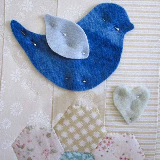 Little bird pinned to the studio mini wall quilt. WonderFil Specialty Threads.