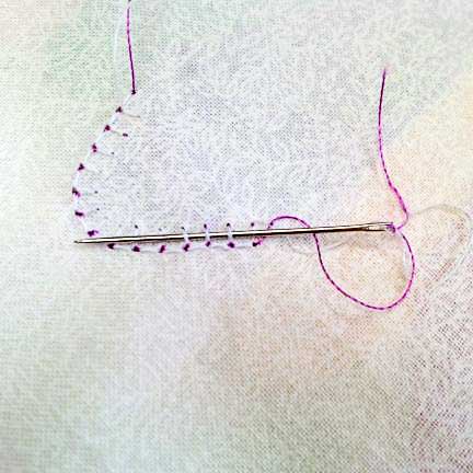 Bury the thread tails under a row of stitching on the back of the work