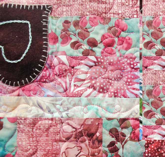 A close up of the heart designs machine quilted on the Valentine's Day tablerunner using WonderFil's Tutti thread.