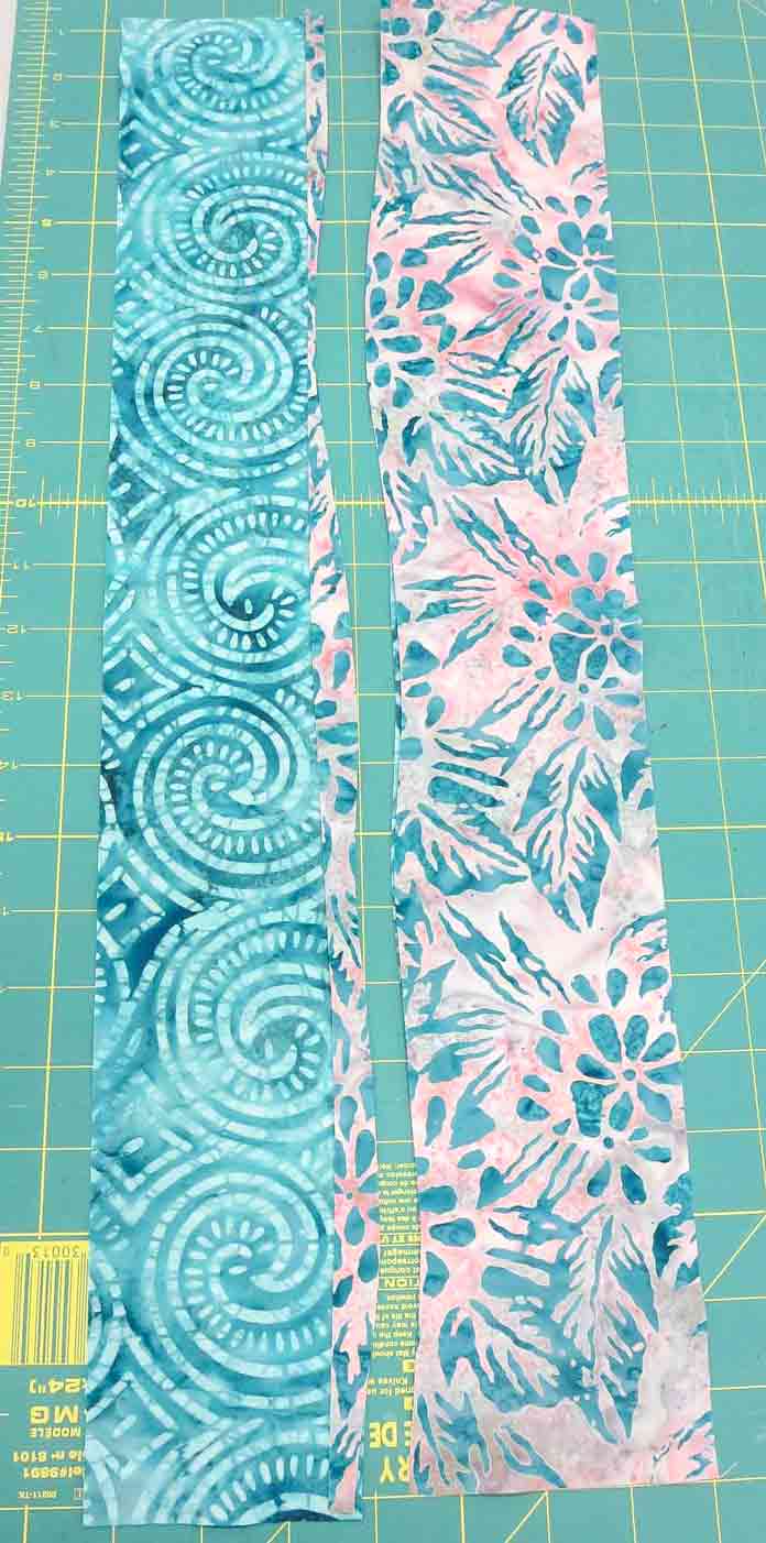 Cut through both layers to make a gentle, wavy cut in preparation for curved strip piecing; using Banyan Batiks Island Vibes fabrics.
