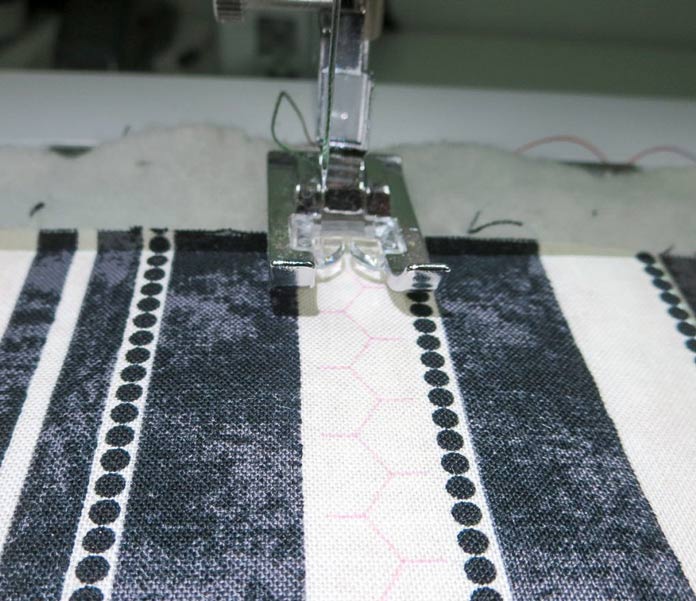 The projector shows the stitch image on the fabric.