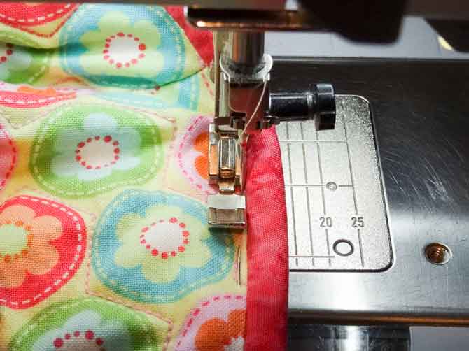 Sew on edge to binding, catching the binding on the inside of the cover,