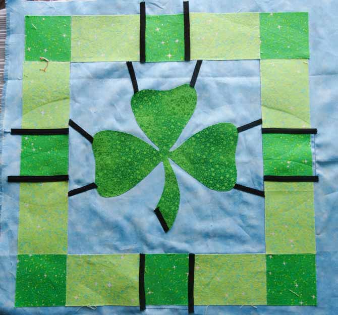 The smallest pieces of bias tape are placed first on the quilt and then ironed into place.