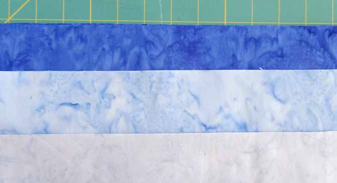 Three blue fabrics with different values will be used to make the 3D blocks with the SEW EASY Half Diamond Ruler.