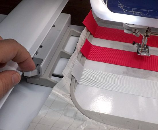 The embroidery hoop with stabilizer and ribbons is locked into the carriage of the Dreamweaver XE. A tutorial on how to make quilt labels using machine embroidery and ribbons using the Brother Dreamweaver XE