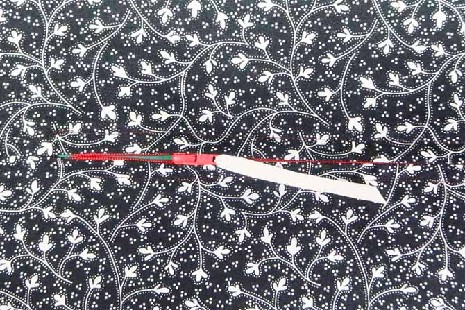 Completed zipper in the seam with ribbon threaded through the zipper pull