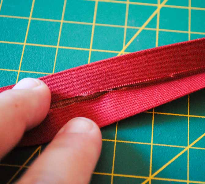 The fabric strip is double folded prior to sewing it onto the edges of the vinyl pockets.