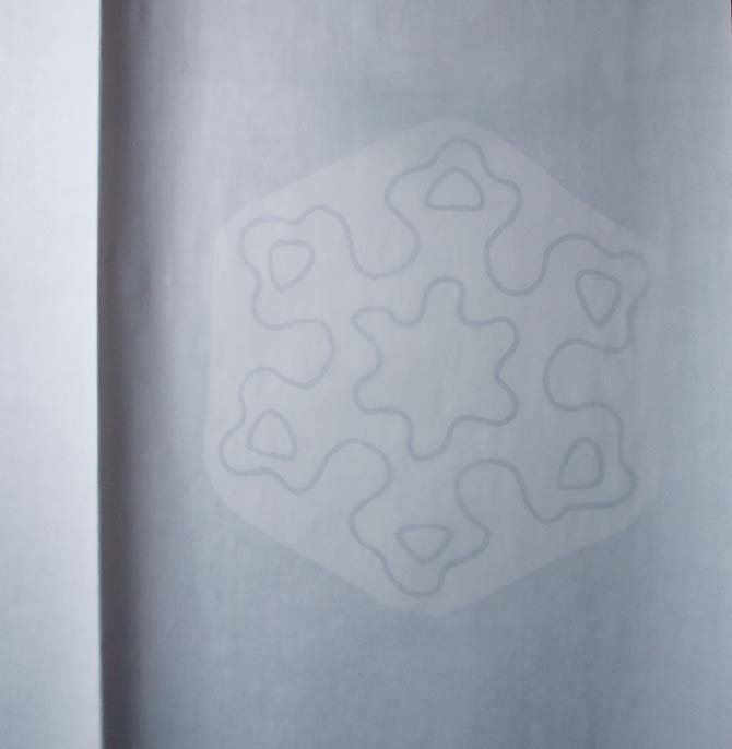 Pressing paper covering the snowflake on fusible web