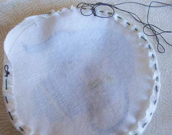 Gather the interfaced circle using a scant hem and a basting stitch in contrasting thread.