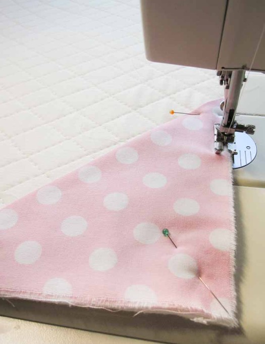 Sew the hanging corners close to the edges of the top of the quilt.