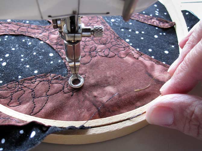 Use a regular hand embroidery hoop, but install the quilt top so that it is flat on the machine bed, to keep the quilt top stable as you create bark on the tree.