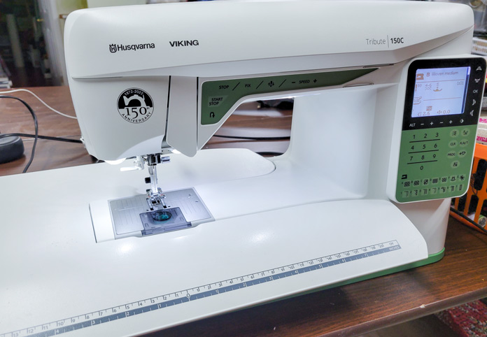 A green and white sewing machine with a white extension table; Husqvarna Viking Tribute 150C