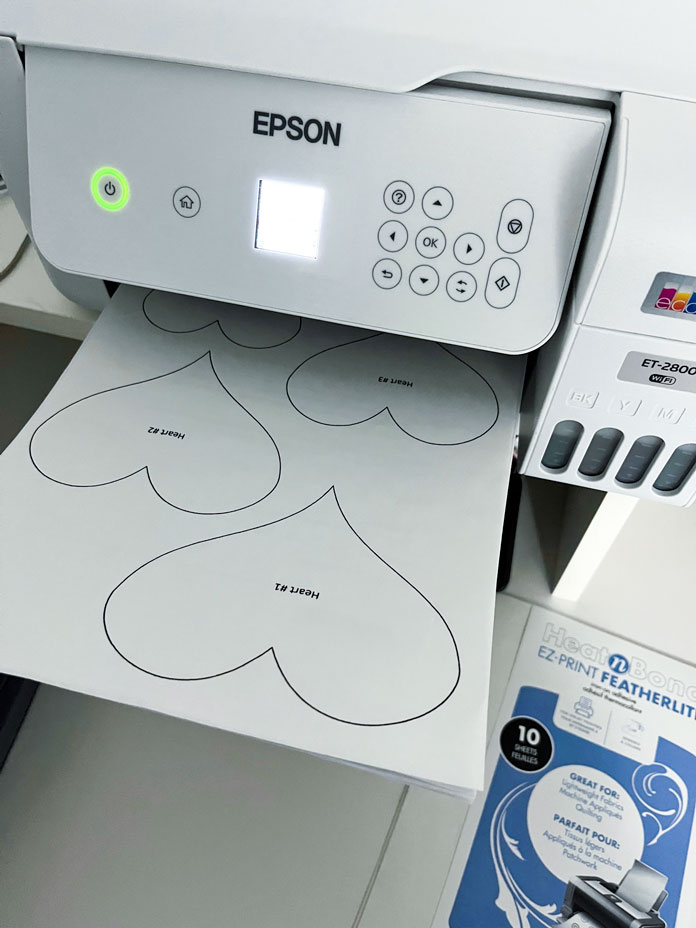 Heart shapes are printed on HeatnBond Featherlite fusible web sheets using an inkjet printer.