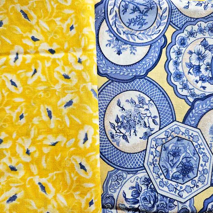 A yellow and blue fabric with small flowers, and a blue and yellow fabric with dishes