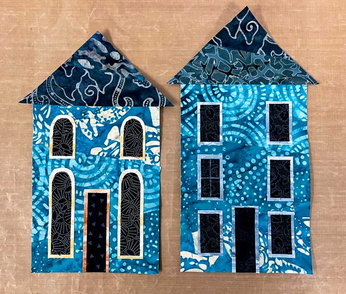 2 pieced turquoise houses with black roofs, doors and windows added.