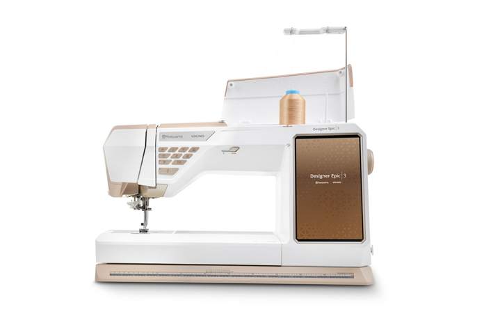 A gold and white sewing machine. Husqvarna VIKING DESIGNER EPIC 3 sewing and embroidery machine, Husqvarna VIKING 6in/15.2cm Applique Scissor, Husqvarna VIKING Open Toe Presser Foot for IDF System, SULKY Slimline Metallic Dream Assortment