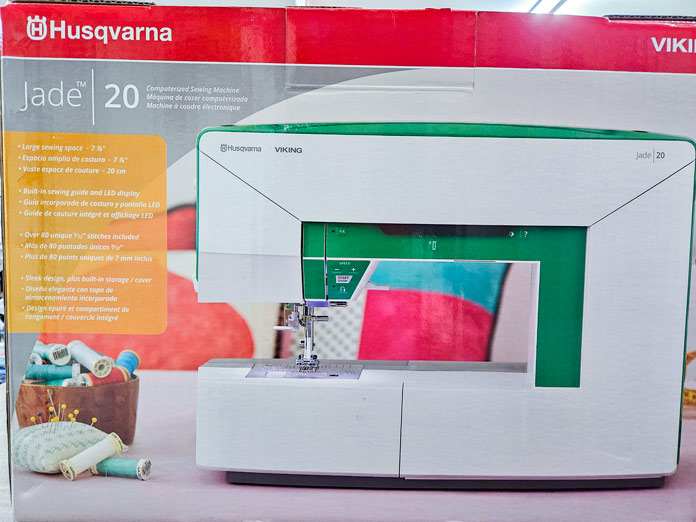 A red and grey box with a green and white sewing machine; Husqvarna VIKING Jade 20, sewing machine review, unboxing sewing machine, Jade 20 features, beginner sewing machine
