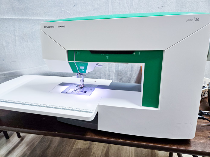 A green and white sewing machine