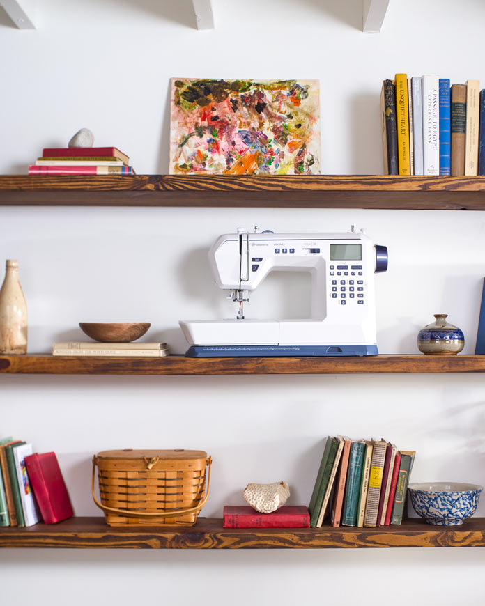 A white sewing machine on a bookshelf