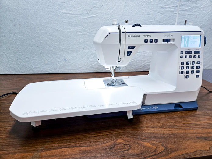 A white sewing machine with an extension table
