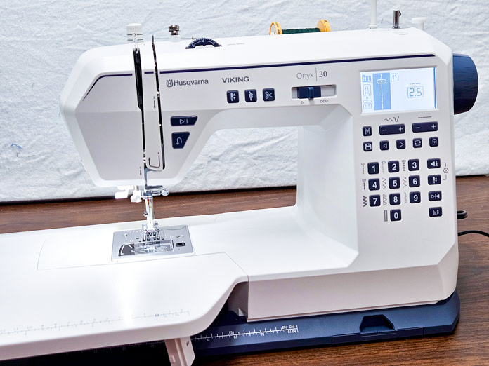 A white sewing machine with an extension table