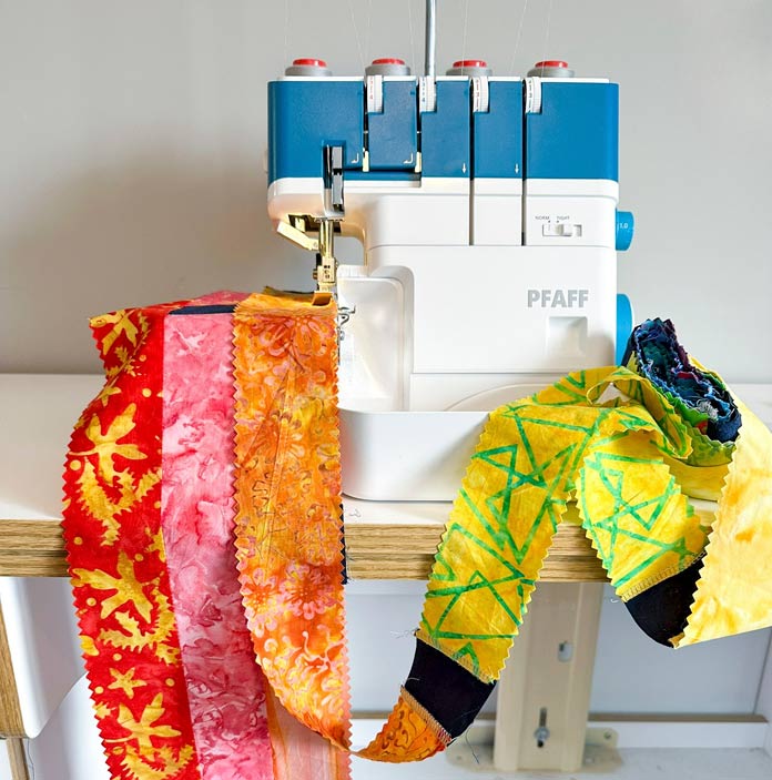 A white and blue serger with a brightly colored jelly roll strip and navy square