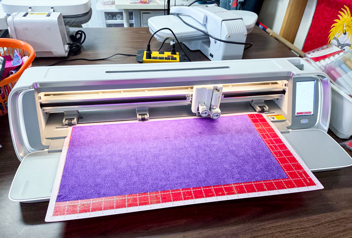 Purple fabric on a digital cutter mat; Singer Moment Fabric Grip Mat