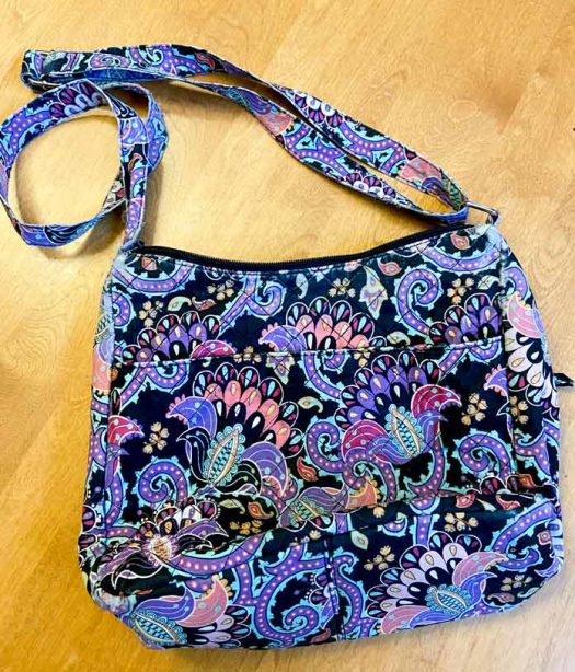 A colorful fabric purse on a wooden table. 